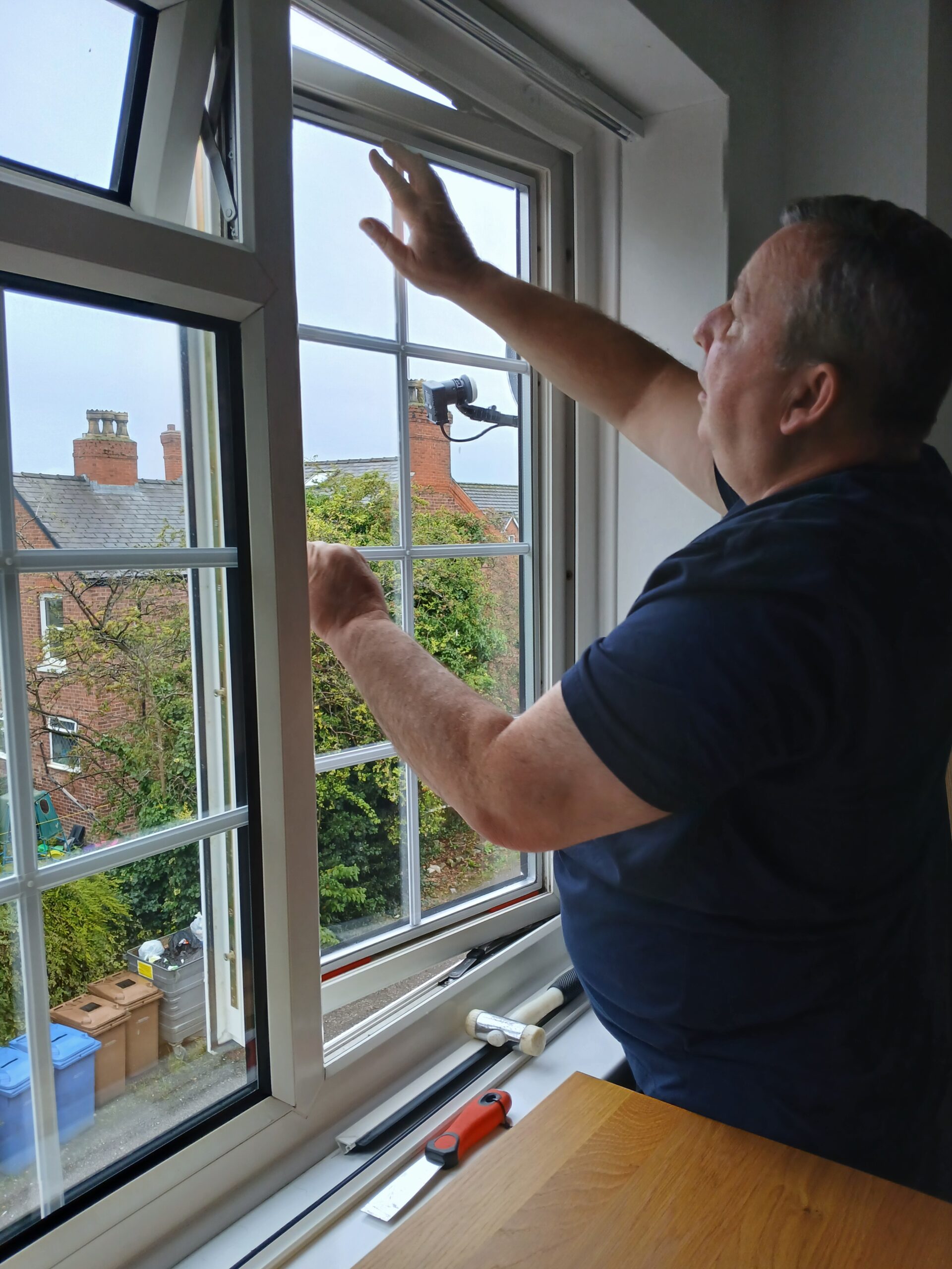 Specialist glazier measuring and installing replacement double glazed window pane